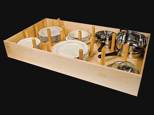 A pegboard drawer box with dishes and pans