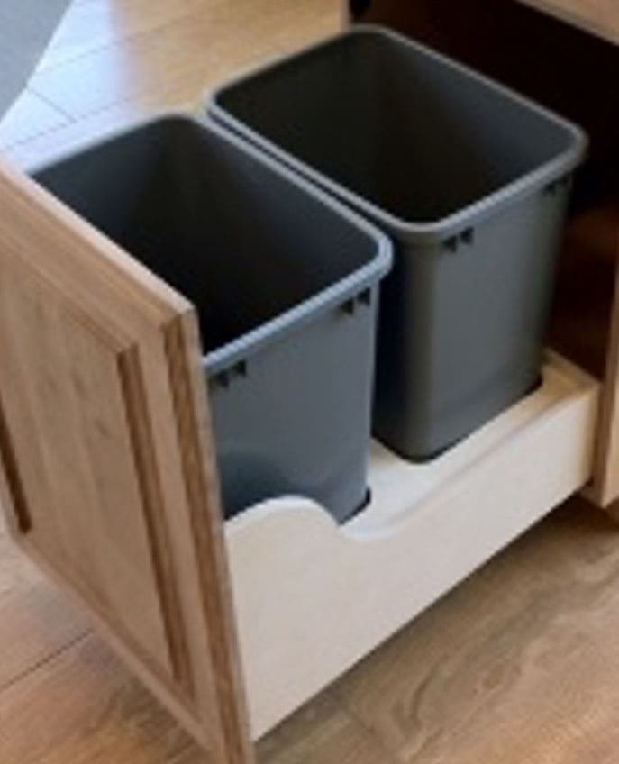 A Dual Trash drawer in a kitchen with two grey trash bins