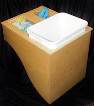 A curved drawer with a waste basket and two holes for plastic and grocery bags