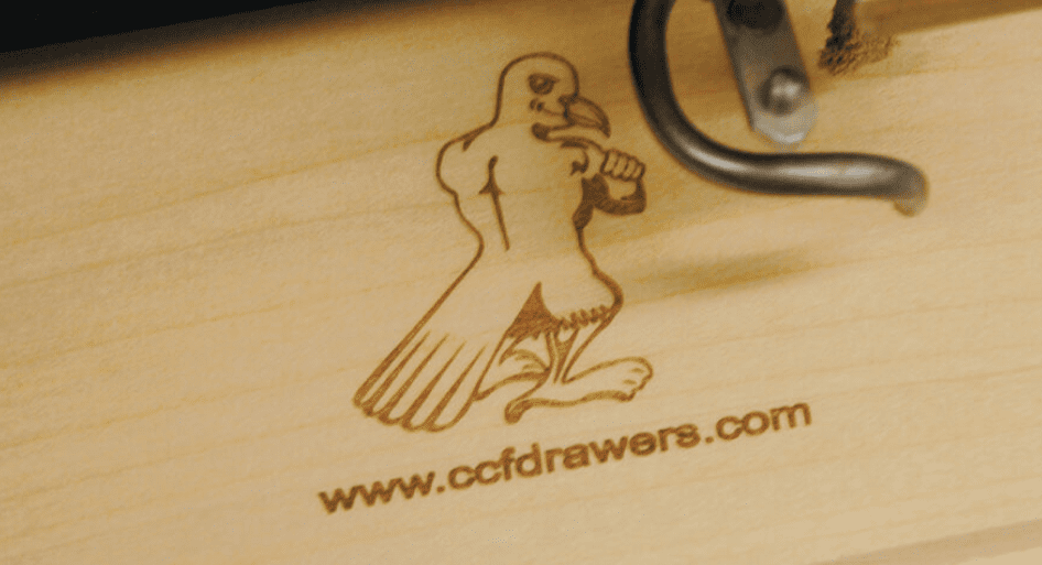 A laser engraved wood plank of the CCF Drawers mascot